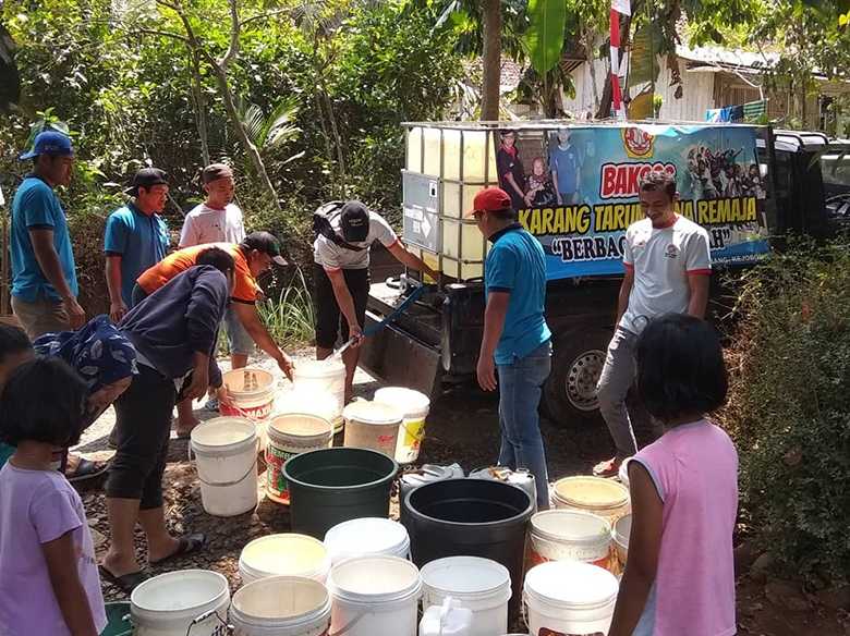 BANTU AIR BERSIH : Karang Taruna Bina Remaja Desa Timbang, Kecamatan Kejobong membantu air bersih untuk warga di desanya yang mengalami kekeringan, Minggu (1/9). (SB/Ryan)