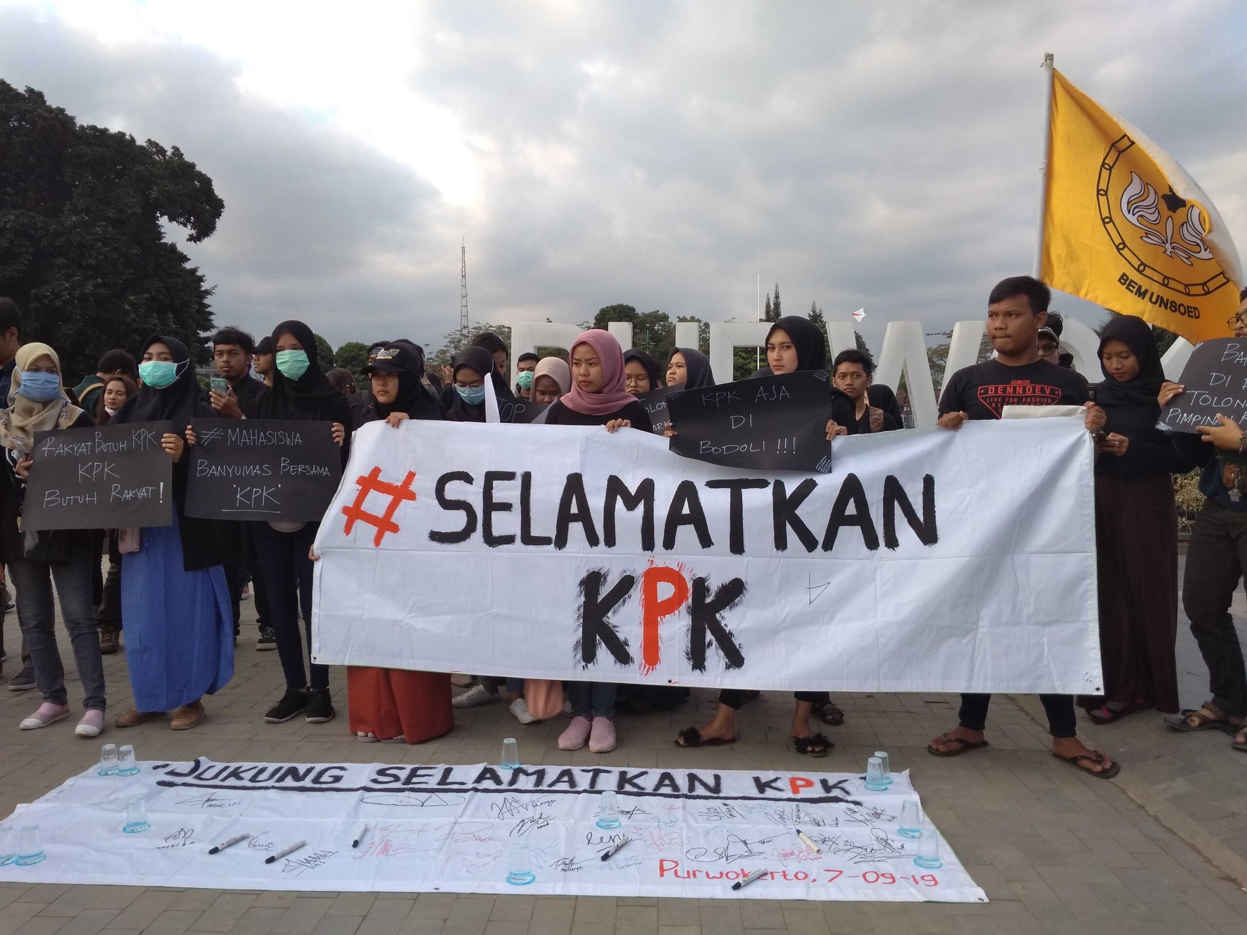 SELAMATKAN KPK: Massa dari Aliansi Mahasiswa Banyumas membentangkan spanduk bertuliskan tagar Selamatkan KPK, saat menggelar aksi di Kompleks Alun-Alun Purwokerto, Sabtu (7/9). (20) (SB/Dhika Wicaksana)
