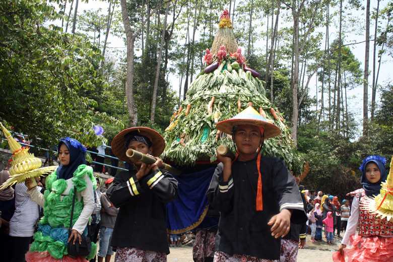 GUNUNGAN: Warga menggotong gunungan hasil bumi pada Grebeg Suran Festival Baturaden,Minggu (22/9). (SB/NP Sukmono)