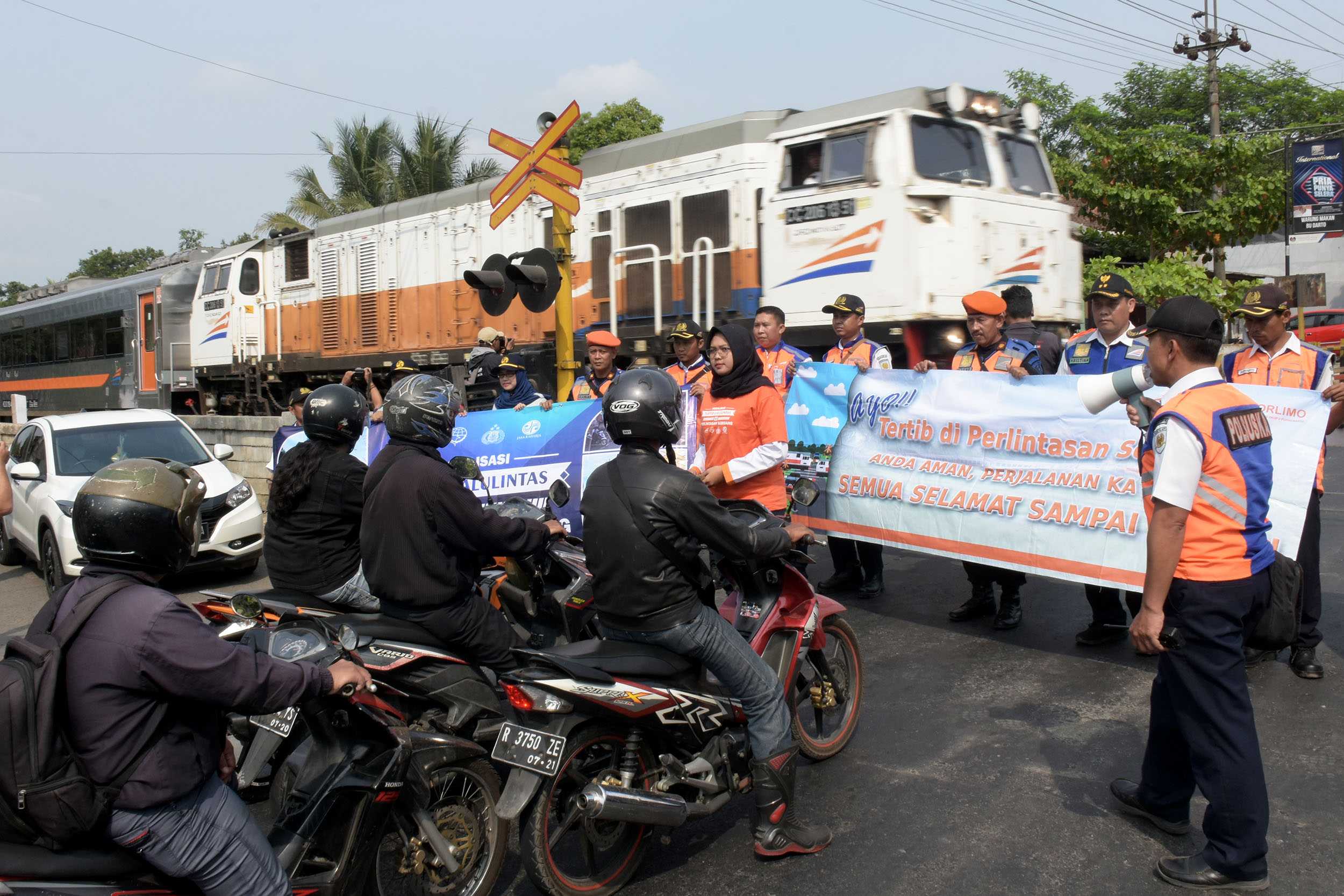SOSIALISASI: Petugas KAI memberikan sosialisasi keselamatan lalu lintas pada perlintasan kereta sebidang di Jalan Veteran Purwokerto, Selasa (17/9) (SB/Dian)