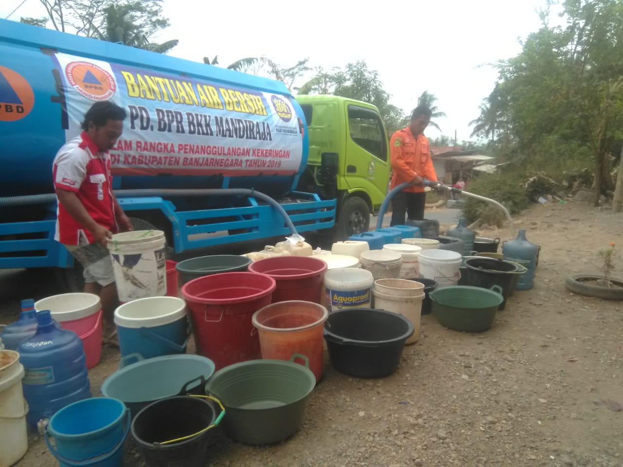 AIR BERSIH: Petugas dari BPBD Banjarnegara mengisi air bersih ke ember dan jeriken milik warga saat pengedropan bantuan air bersih, Senin (23/9). (SB/Castro)