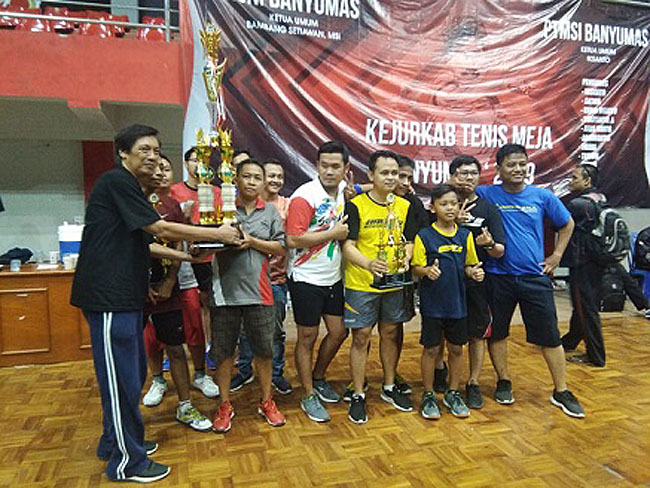 JUARA: Pemain dan ofisial PTM Kalisalak merayakan gelar juara Kejurkab PTMSI Banyumas, di GOR Satria, Purwokerto, Sabtu (21/9). (SB/Budi H).