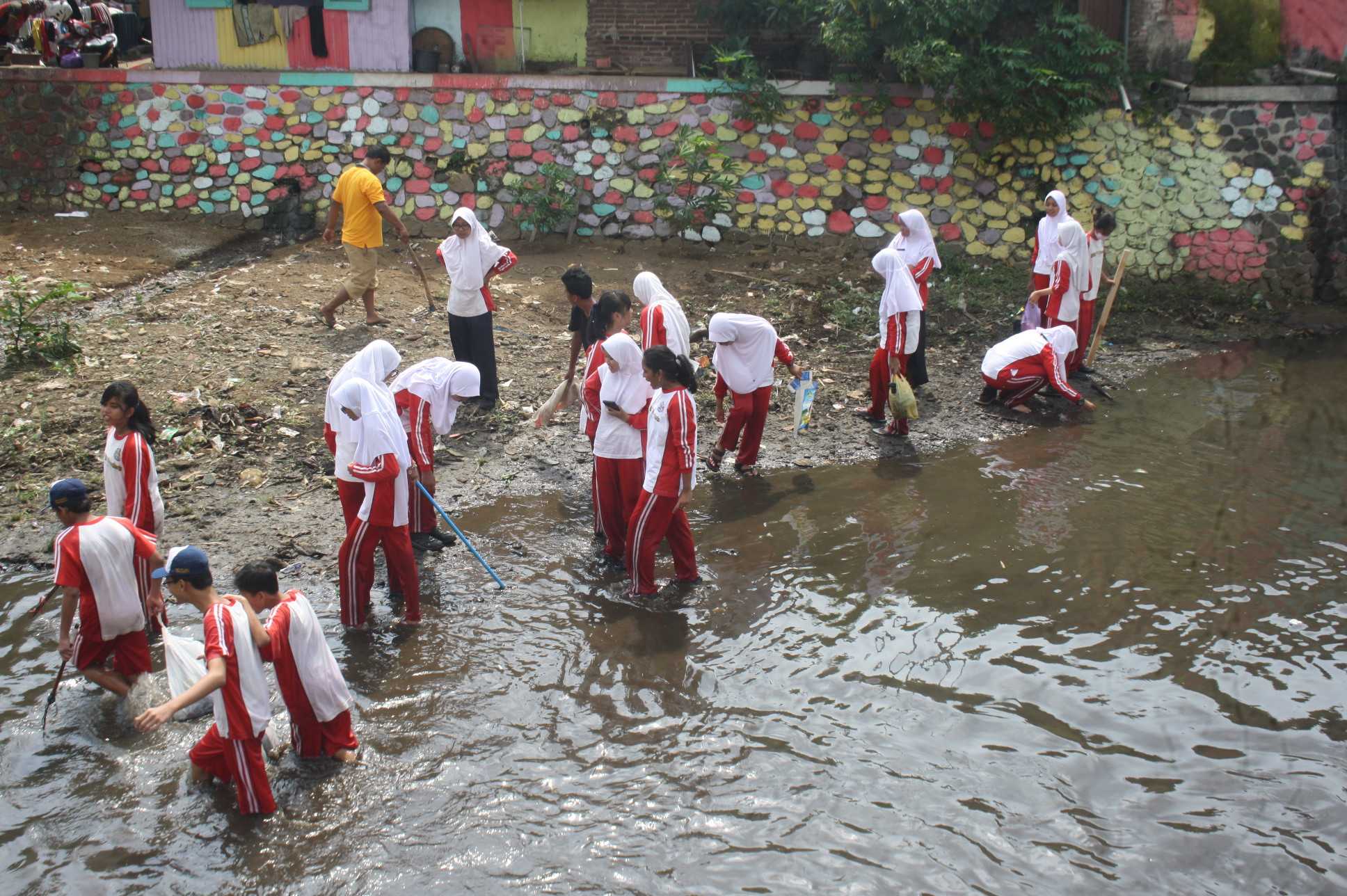 PUNGUT SAMPAH:Sejumlah siswa SMP di Purwokerto memungut sampah di Sungai Kranji yang dapat mengganggu aliran air, baru-baru ini.