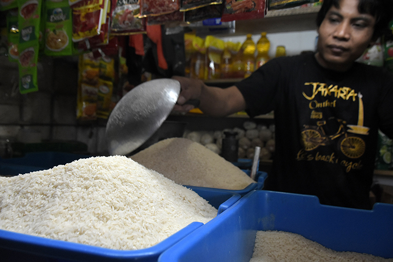 TAKAR BERAS: Pedagang sembako menakar beras pesanan pembeli, di Pasar Manis Purwokerto, Senin (2/9)
