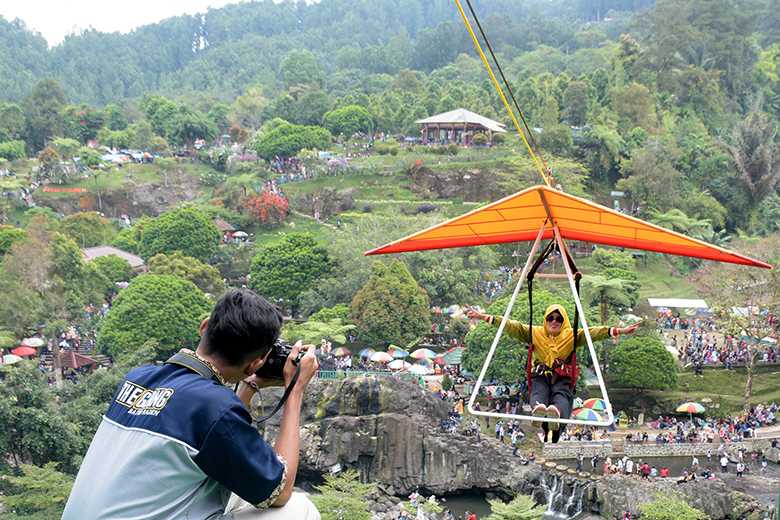 JAJAL WAHANA:
Pengunjung menjajal wahana paralayang di Lokawisata Baturraden, belum lama ini.