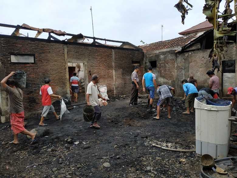 BERSIHKAN PUING : Warga dam petugas membersihkan puing sisa kebakaran yang menimpa rumah Rasmin Pamuji (67) warga Desa Selabaya, Kecamatan Kalimanah, Selasa (8/10) dini hari.
