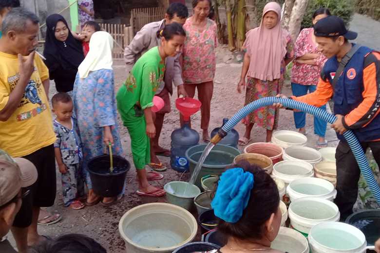 TERIMA BANTUAN: Sejumlah warga terdampak bencana kekeringan di Dusun Kawungcarang Desa Pangawaren Kecamatan Karangpucung Kabupaten Cilacap menerima bantuan air, Jumat (4/10).