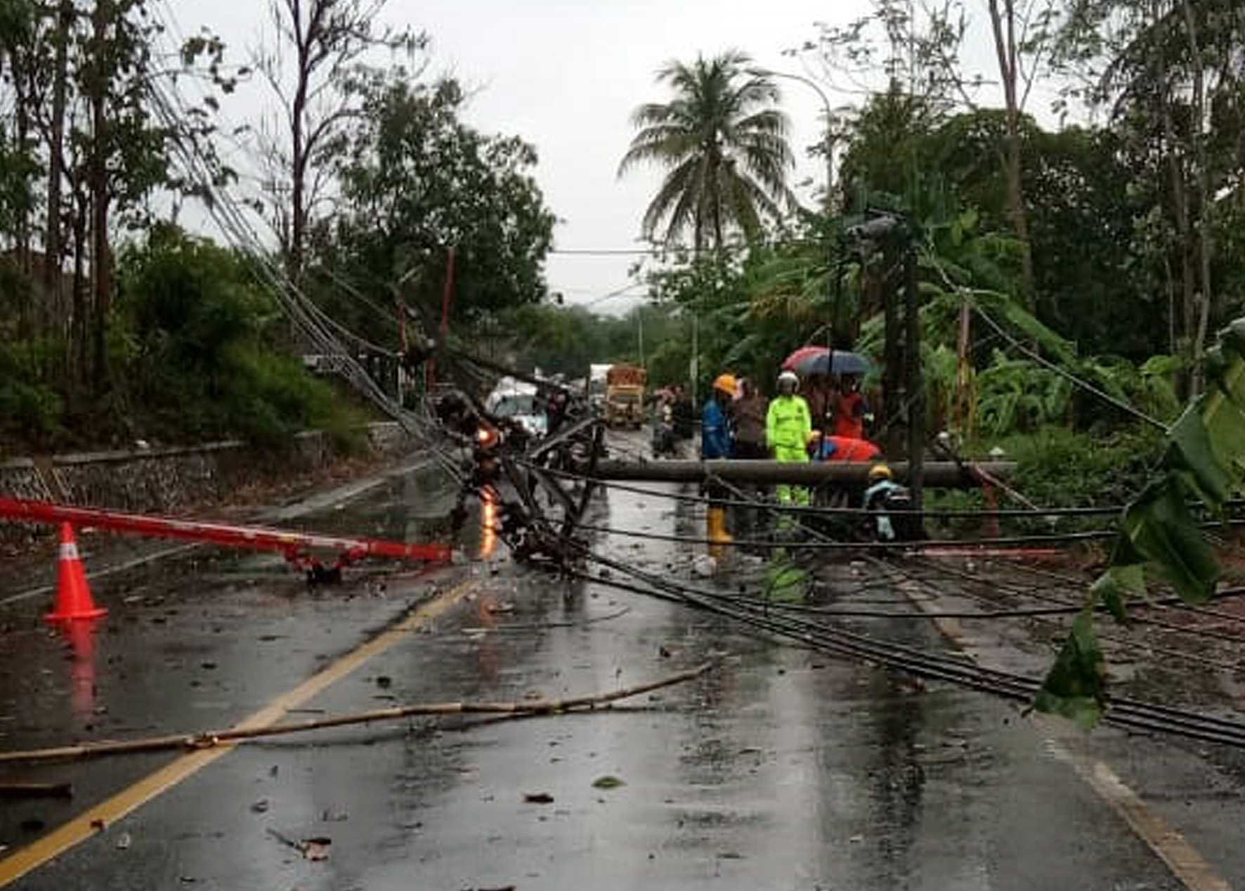 TUMBANG: Tiang listrik di tepi jalan raya Ajibarang-Wangon tepatnya di Desa Cikakak, Kecamatan Wangon tumbang dan melintang di jalan raya, Kamis (14/11) siang. (SB/dok)