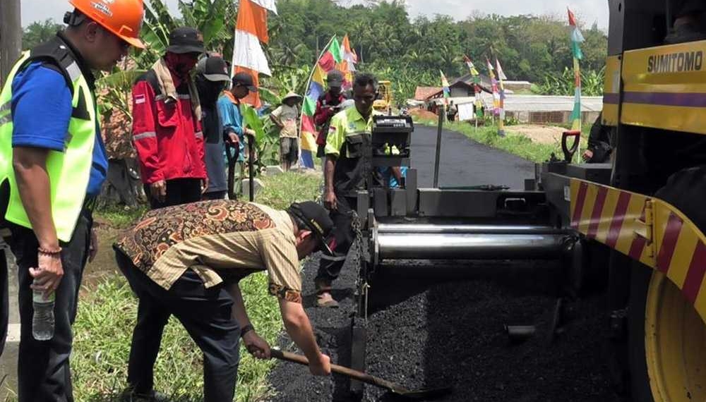 UJI COBA: Bupati Achmad Husein meratakan aspal dengan sekop saat uji coba aspal campuran plastik di Desa Kedungwuluh Lor, Kecamatan Patikraja, baru-baru ini. (SB/dok humas Pemkab Banyumas)