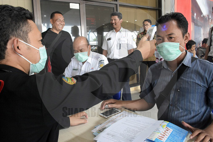 PERIKSASUHU TUBUH:Petugas melakukan simulasi pemeriksaan suhu tubuh di Stasiun Purwokerto padaSelasa (28/1).(20) (SM/Dian Aprilianingrum)