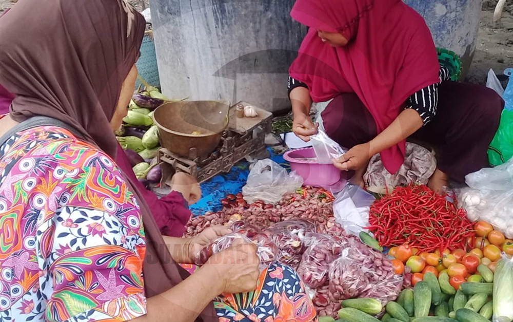 MEMBUNGKUS DAGANGAN: Pedagang membungkus dagangan bawang merah di Pasar Karangpucung, Cilacap, baru-baru ini. (SM/Teguh Hidayat Akbar-52)