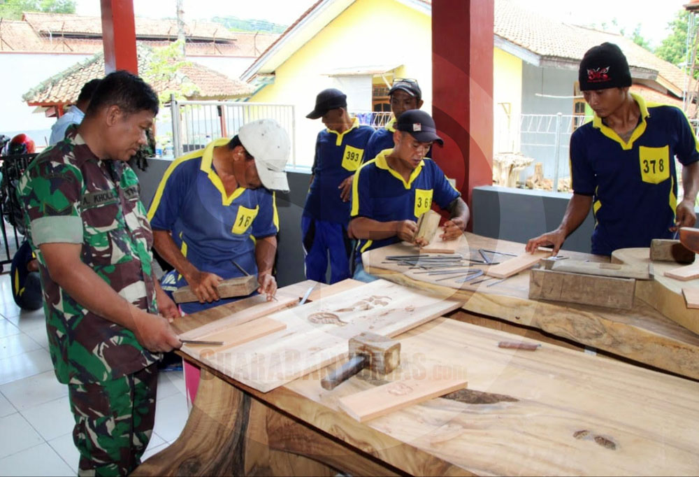 BERI PEMBINAAN: Babinsa Kodim 0703 Cilacap, Sertu A Kholiq ketika sedang memberikan pembekalan keterampilan seni ukir kayu kepada warga binaan Lapas Kembangkuning Nusakambangan.(SM/Agus Sukaryanto-52)