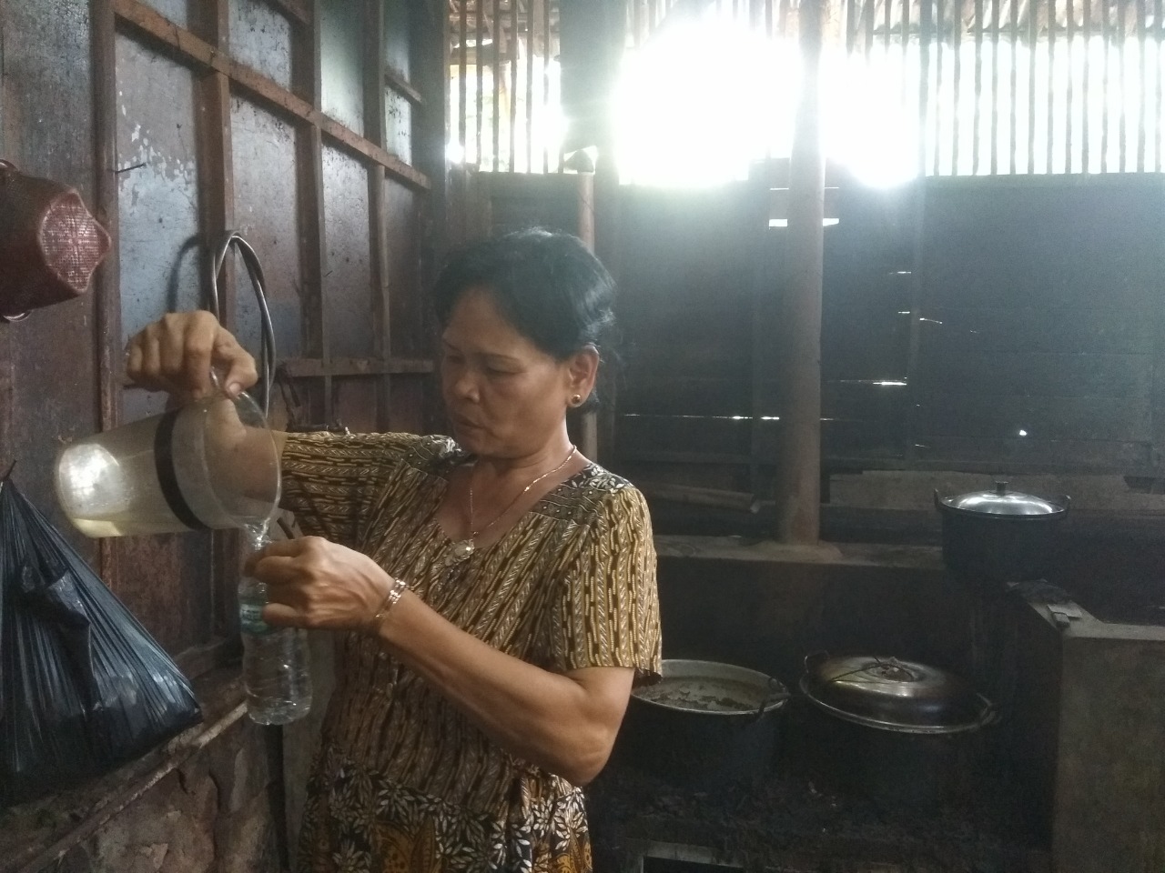 TUANG CIU: Perajin ciu asal Desa Wlahar, Kecamatan Wangon menuang ciu ke dalam wadah di dapur produksi ciu kemarin.