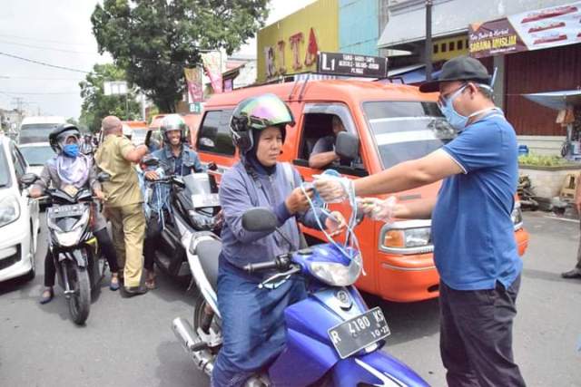BAGIKAN MASKER: Bupati Achmad Husein terlibat langsung membagikan masker gratis kepada pengguna jalan didepan Alun-alun Purwokerto, Senin (23/3). Ada 1.000 makser dan 400 botol hand sanitizer dibagikan secara gratis.(SM/Agus Wahyudi)