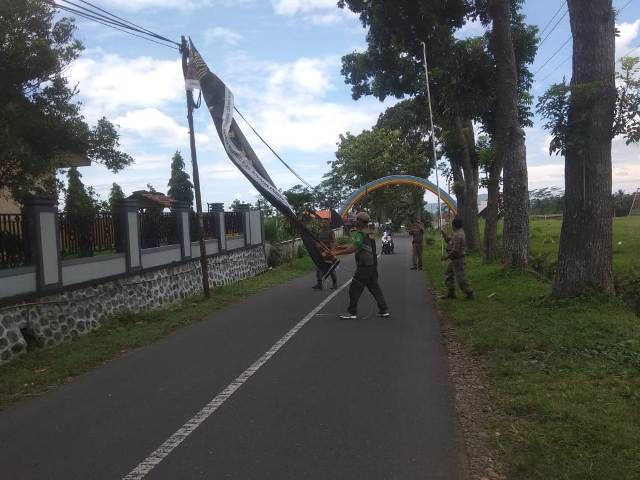 TERTIBKAN SPANDUK: Personel Satpol PP Banyumas menertibkan spanduk melintang di jalur wisata Curug Cipendok, Desa Karangtengah, Kecamatan Cilongok kemarin.