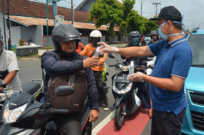 HAND SANITIZER CIU : Bupati Banyumas Achmad Husein membagikan hand sanitizer berbahan ciu dan masker pada pengendara yang melintas di Jalan Jendral Soedirman Purwokerto, Senin (23/3). (SM/Dian Aprilianingrum)