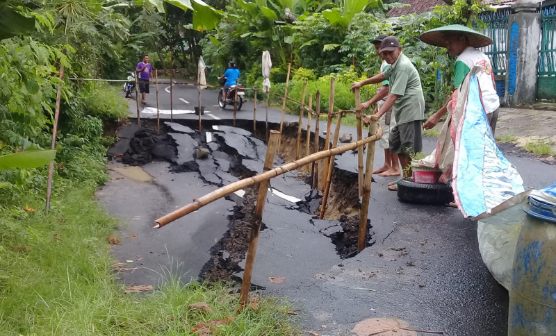 JALAN AMBLES: Sejumlah warga melihat kondisi jalan kabupaten yang ambles di Desa/Kecamatan Karangpucung, Kabupaten Cilacap, Kamis (5/3). (SM/Teguh Hidayat Akbar-52)