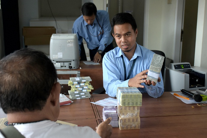 PENUKARAN UANG : Pegawai BI Purwokerto melayani warga yang melakukan penukaran uang baru di tempat penukaran uang, beberapa waktu lalu. (SM/Dian Aprilianingrum)