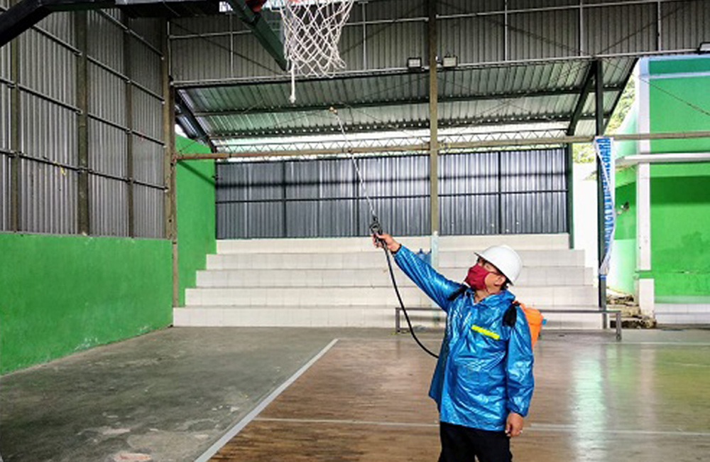 PENYEMPROTAN-Petugas KONI melakukan penyemprotan disinfektan di indoor bola basket Banjarnegara. (SM/dok).