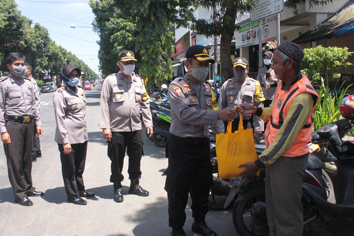 SERAHKAN BANTUAN: Aparat dari Polres Banjarnegara menyerahkan bantuan paket sembako kepada juru parkir yang bertugas di depan Mapolres Banjarnegara.SM/Castro Suwito)