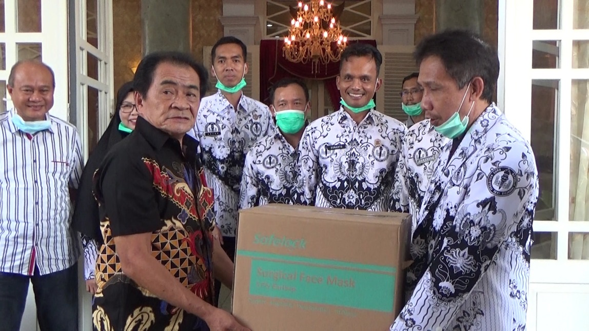 SERAHKAN BANTUAN: Ketua PGRI Banjarnegara Noor Tamami menyerahkan bantuan berupa alat pelindung diri (APD) penanganan wabah Covid-19 kepada Bupati Banjarnegara Budhi Sarwono.(SM/Castro Suwito)