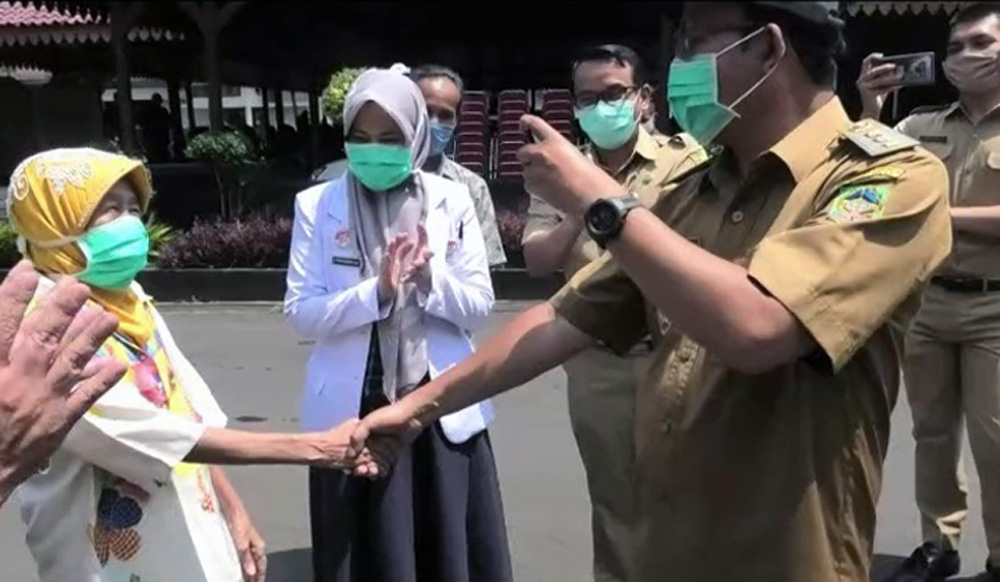 BERSALAMAN: Bupati Achmad Husein bersalaman dengan pasien Covid-19 yang dinyatakan sembuh asal Desa Batuanten Kecamatan Cilongok saat bertemu di kabupaten, Senin (20/4) lalu. (SM/dok)