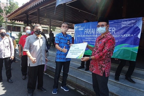 MENYERAHKAN BANTUAN :  Bupati Banyumas, Achmad Husein didampingi Kepala Kantor BPJAMSOSTEK Cabang Purwokerto, Agus Widiyanto menyerahkan bantuan secara simbolis kepada Kepala Dinnakerkop UKM, Joko Wiyono di Pendapa Sipanji Purwokerto, Selasa (12/5). (SB/Puji Purwanto)