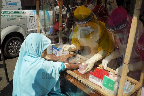 RAPID TEST: Petugas kesehatan sedang mengambil sampel darah dari salah seorang 
pedagang untuk dilakuan rapid test Covid-19 di kompleks Pasar Kota Banjarnegara. (SM/Castro Suwito)