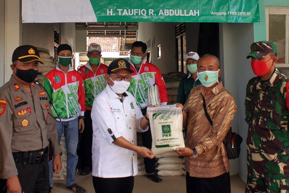 SERAHKAN BANTUAN: Anggota Fraksi PKB DPR RI Taufiq R Abullah secara simbolis menyerahkan bantuan berupa beras kepada warga terdampak pandemi Covid-19 total sebanyak 19 ton beras. (SM/Castro Suwito-30)