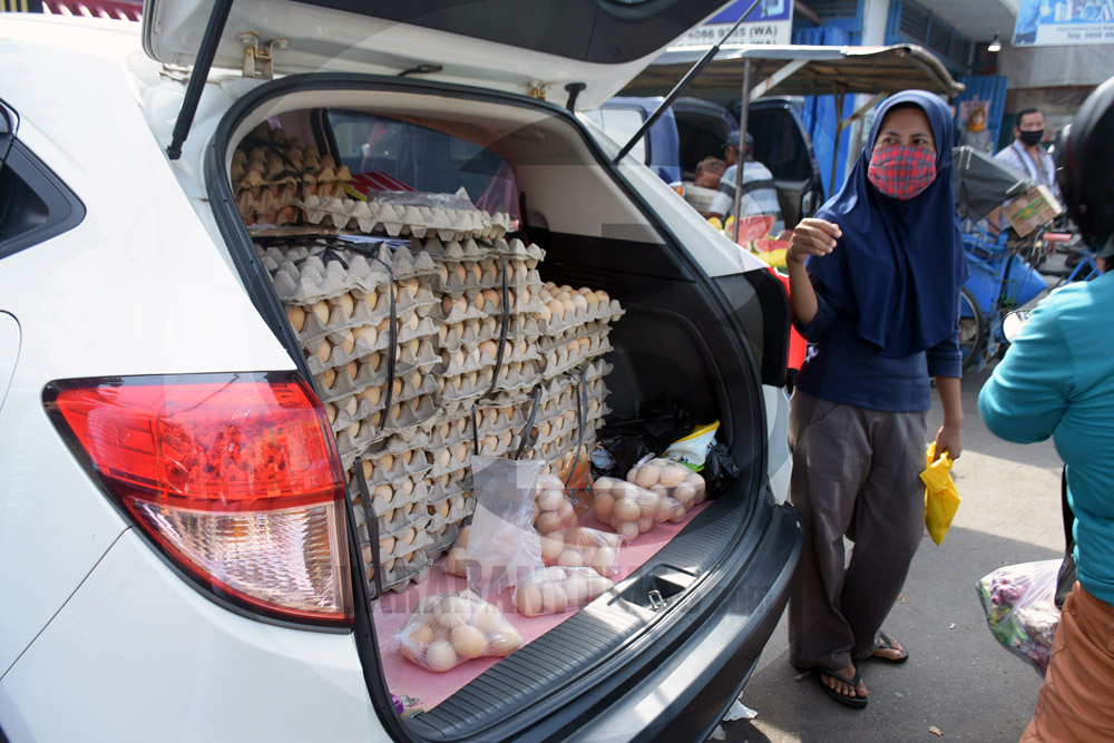 LAYANI PEMBELI: Pedagang melayani warga yang akan membeli telur infertil dagangannya di Pasar Wage Purwokerto, Rabu (13/5) (SM/Dian Aprilianingrum)