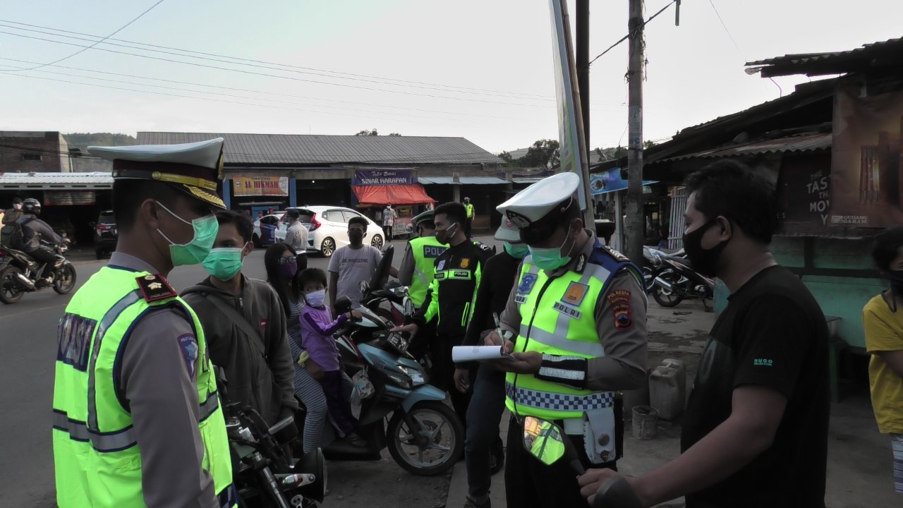 OPERASI MASKER: Petugas gabungan  menilang di tempat bagi pelanggar tal bermasker saat berada di jalan raya, di depan Pasar Patikraja, Rabu, 3 Juni 2020.(SM/Agus Wahyudi)