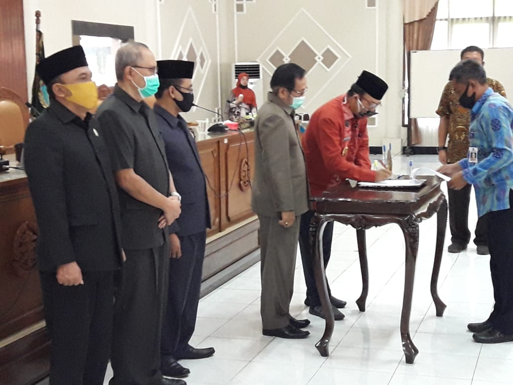 PERSETUJUAN BERSAMA: Bupati Achmad Husein menandatangani persetujuan bersama atas Raperda Pertanggungjawaban Pelaksanaan APBD 2019, diikuti ketua dan tiga wakil ketua DPRD dalam rapat paripurna, Rabu (15/7).(SM/Agus Wahyudi)