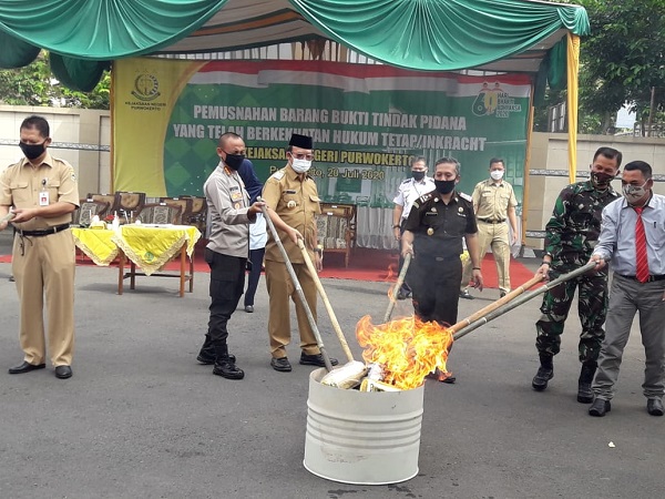 DIMUSNAHKAN BERSAMA : Kepala Kejaksaan Negeri Purwokerto, Sunarwan (tengah) bersama unsur Forkopimda dan pimpinan instansi vertikal lain memusnahkan secara simbolis barang bukti hasil kejahatan di halaman Kejari Purwokerto, Senin (20/7). (SB/Agus Wahyudi)