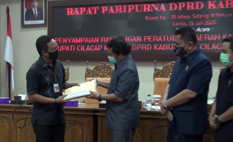 SERAHKAN RAPERDA: Wakil Bupati Cilacap, Syamsul Auliya Rachman menyerahkan draf Raperda kepada Pimpinan DPRD di ruang paripurna, Kamis (16/7). (SB/Dokumentasi DPRD Cilacap)