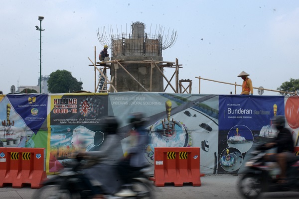 PEMBANGUNAN TUGU: Pengendara melintas di dekat Tugu Gada Rujakpolo yang sedang dibangun di pintu masuk underpass Purwokerto, Senin (10/8). (SB/Dian Aprilianingrum)