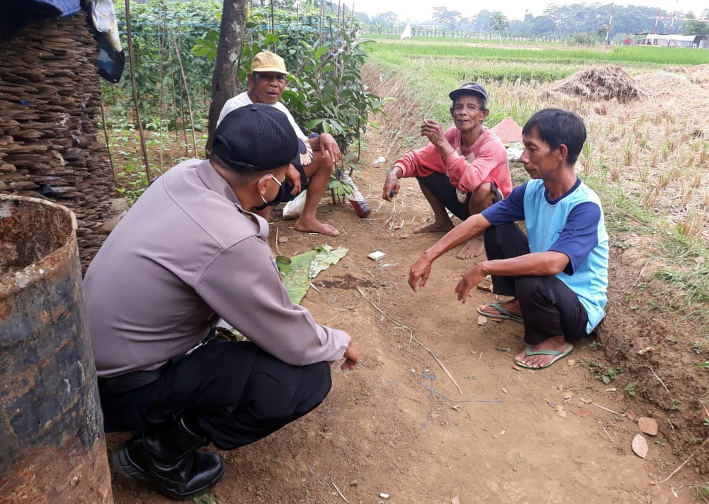 DIALOG : Anggota Bhabinkamtibmas Polsek Purwokerto Utara berdialog dengan petani penggarap di lahan banda desa di Kelurahan Grendeng, Purwokerto Utara, Sabtu (16/8). (SM/Humas Polresta Banyumas)