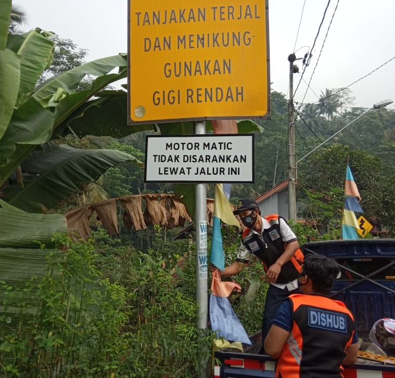 PASANG RAMBU LALU LINTAS: Petugas dari Dinas Perhubungan memasang rambu-rambu lalu lintas di jalur ekstrem Cikawung-Semedo Kecamatan Pekuncen, Rabu (5/8).