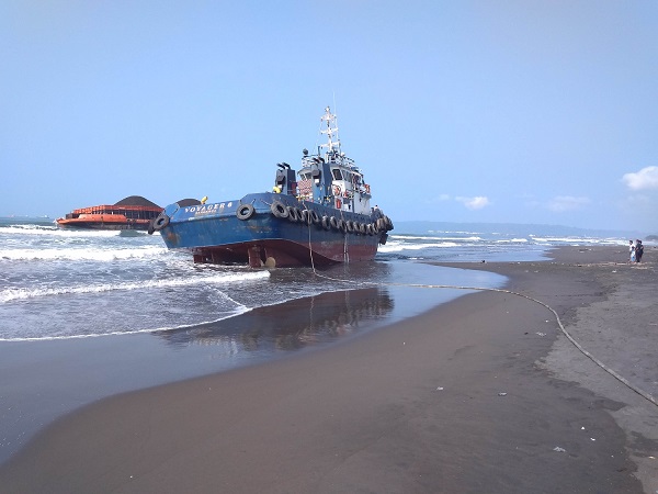 TERDAMPAR: Kapal tugboat Voyager 6 dan tongkang Ocean Master 206 bermuatan sekitar 9.000 metrik ton batubara, terdampar di perairan sekitar TPI Kemiren, Cilacap, sejak Jumat (24/7). 
(SB/Gayhul Dhika Wicaksana)