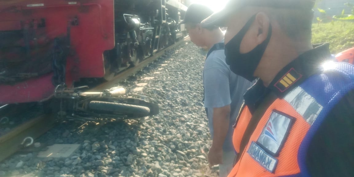 KECELAKAAN: Sepeda motor yang digunakan korban, tergeletak di depan lokomotif setelah terjadi benturan akibat menerobos palang pintu perlintasan kereta api.