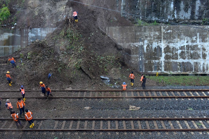 BERSIHKAN LONGSOR: Pekerja membersihkan tanah longsor yang menimbun rel ganda kereta api di dekat terowongan Kebasen, Banyumas, Kamis (29/10) (SB/Dian A)